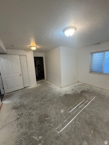 1976 River Bottom Road Springville, UT 84663 - Photo 43 of 45 Spacious interior room featuring a concrete subfloor, white painted walls, and window with blinds