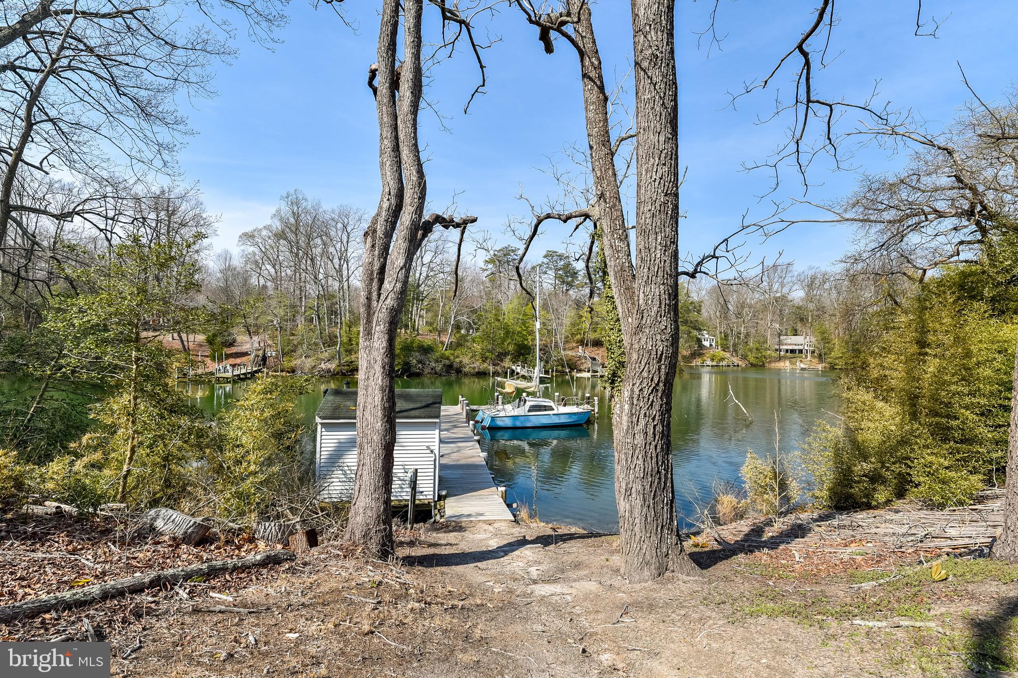 23690 West Patuxent Beach Road California, MD 20619 - Photo 15 of 39 a view of a lake with a bench and trees