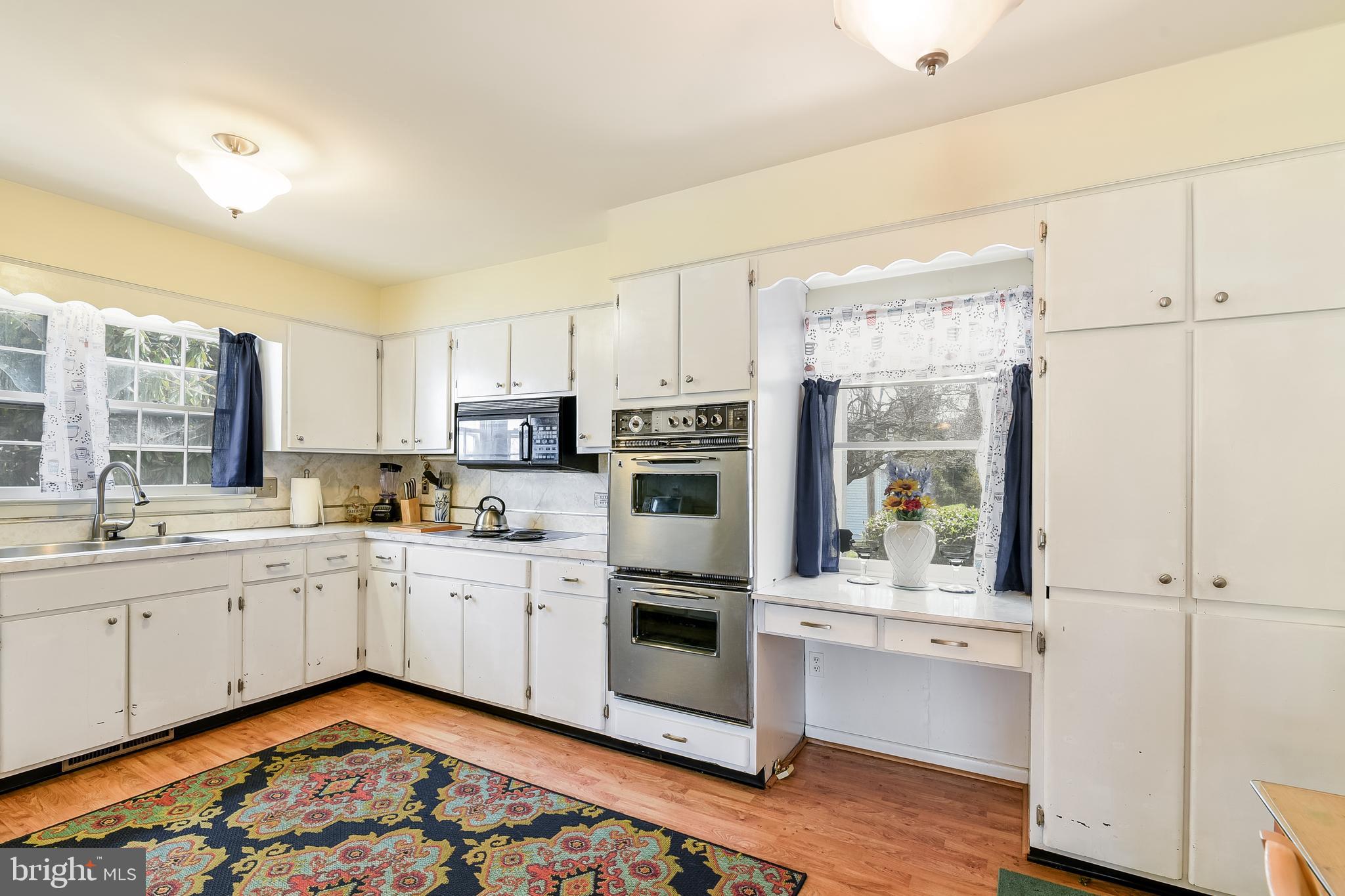 23690 West Patuxent Beach Road California, MD 20619 - Photo 31 of 39 a kitchen with stainless steel appliances granite countertop a refrigerator a stove and white cabinets with wooden floor