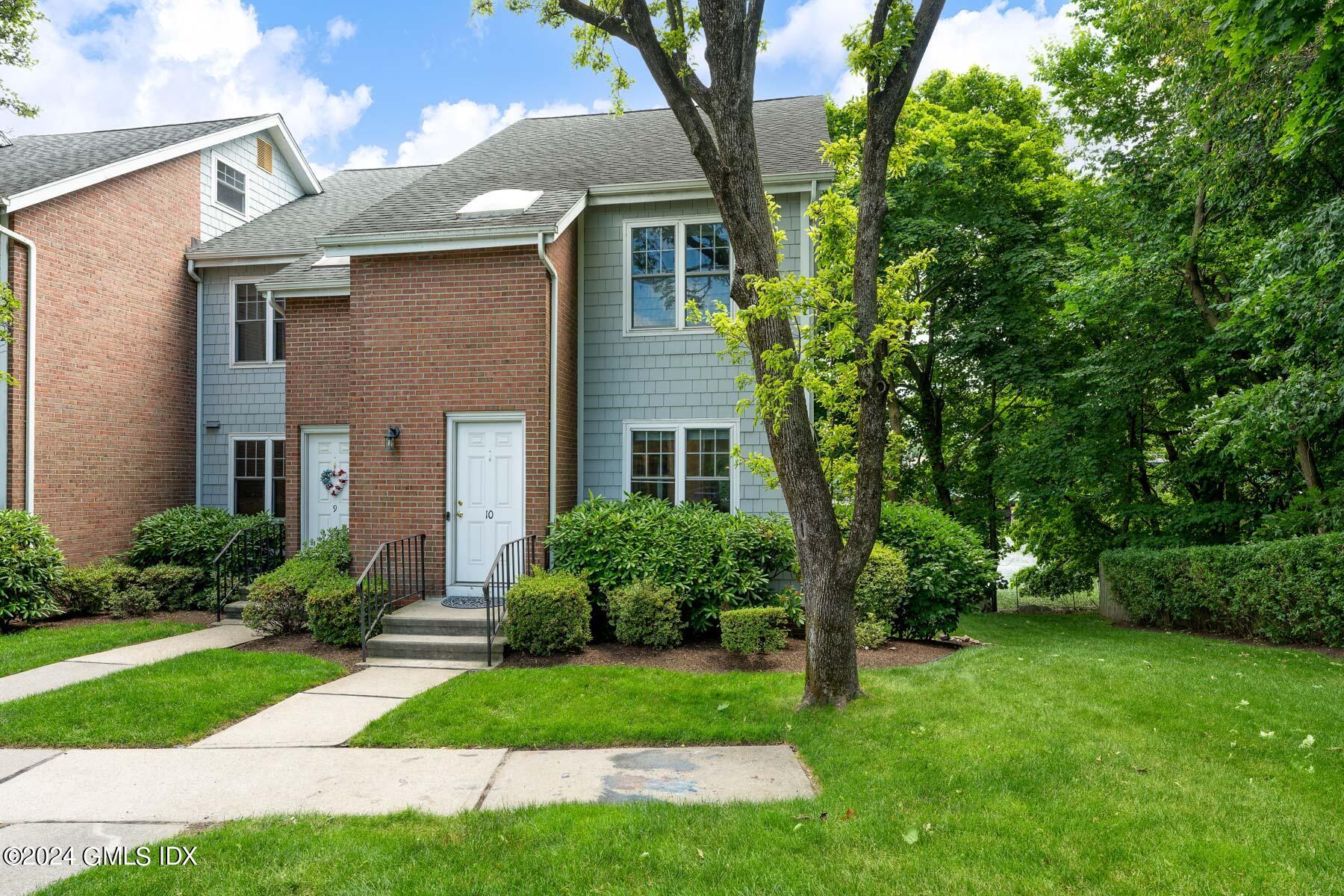 100 Strickland Road, Unit 10 Cos Cob, CT 06807 - Photo 2 of 26 a front view of a house with a yard