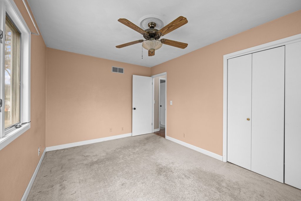 1141 Mark Street Colona, IL 61241 - Photo 17 of 29 a view of an empty room with window and ceiling fan