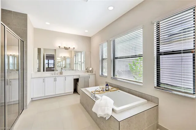 a spacious bathroom with a granite countertop tub sink and mirror
