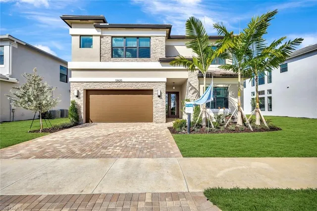 a front view of a house with a garden and yard