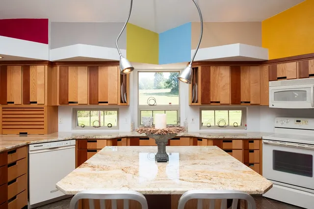 a kitchen with a stove a table and chairs in it