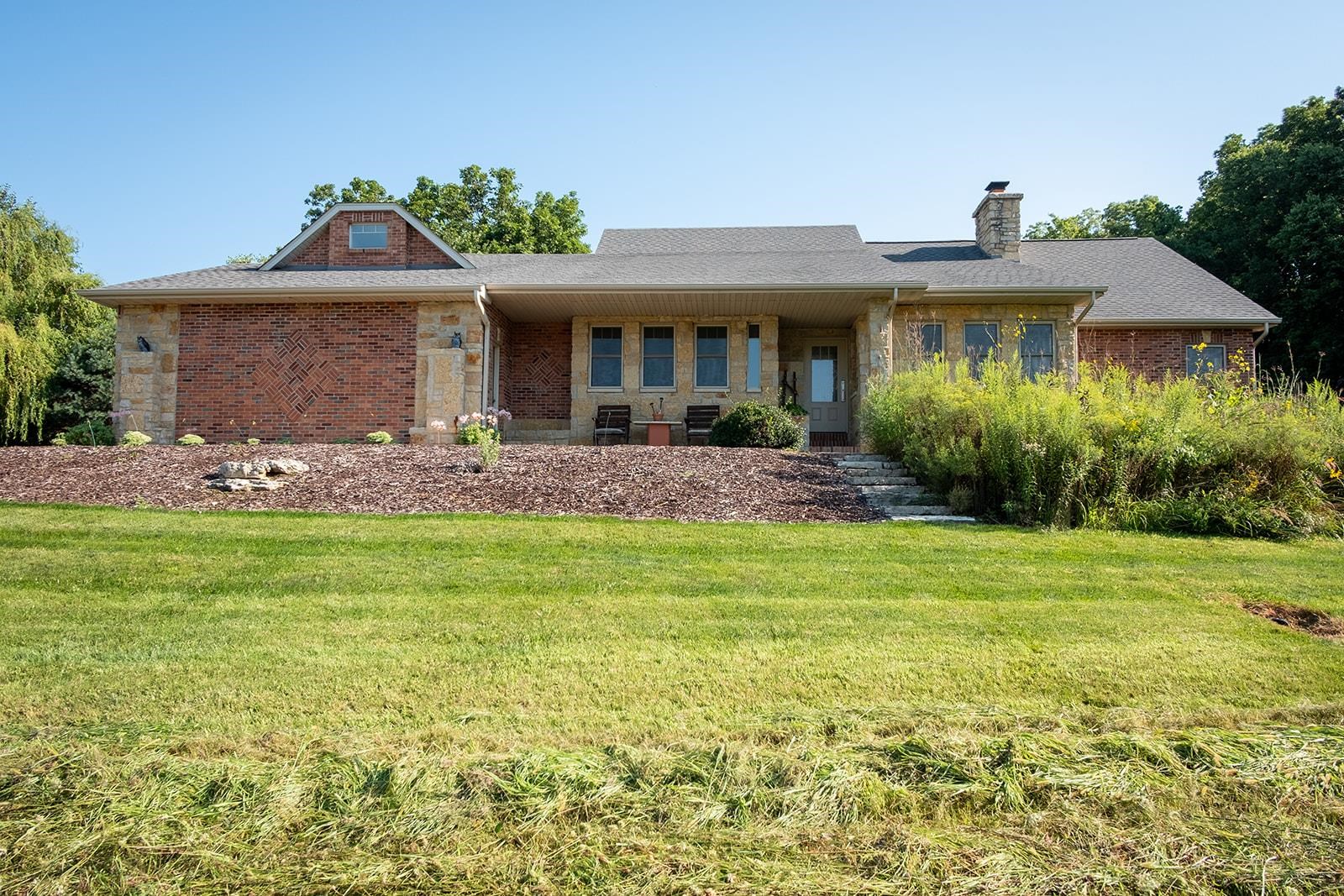 7822 Burr Oak Road Roscoe, IL 61073 - Photo 5 of 53 a front view of a house with a garden