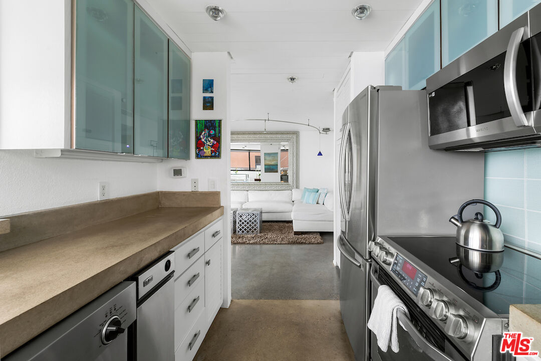 6209 Pacific Avenue, Unit 104 Playa del Rey, CA 90293 - Photo 12 of 18 a kitchen with stainless steel appliances granite countertop a sink stove and refrigerator