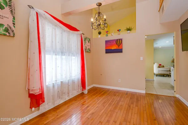 a view of a room with wooden floor and entryway