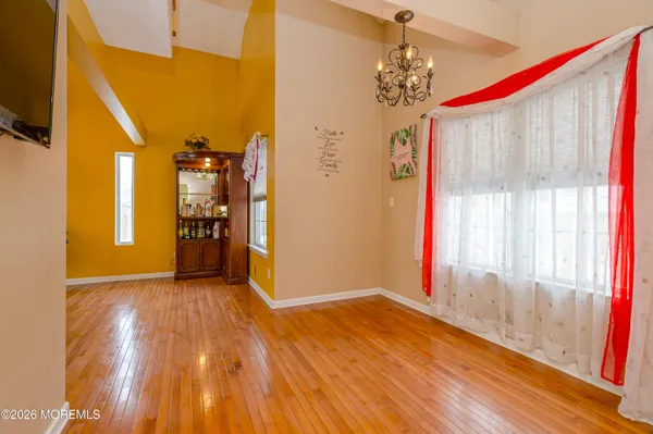 a dining room with furniture a chandelier and kitchen view