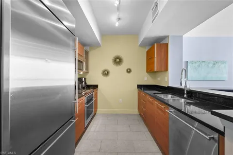 a kitchen with granite countertop a refrigerator and a sink