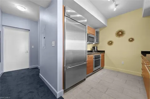 a kitchen with stainless steel appliances granite countertop a refrigerator and a sink