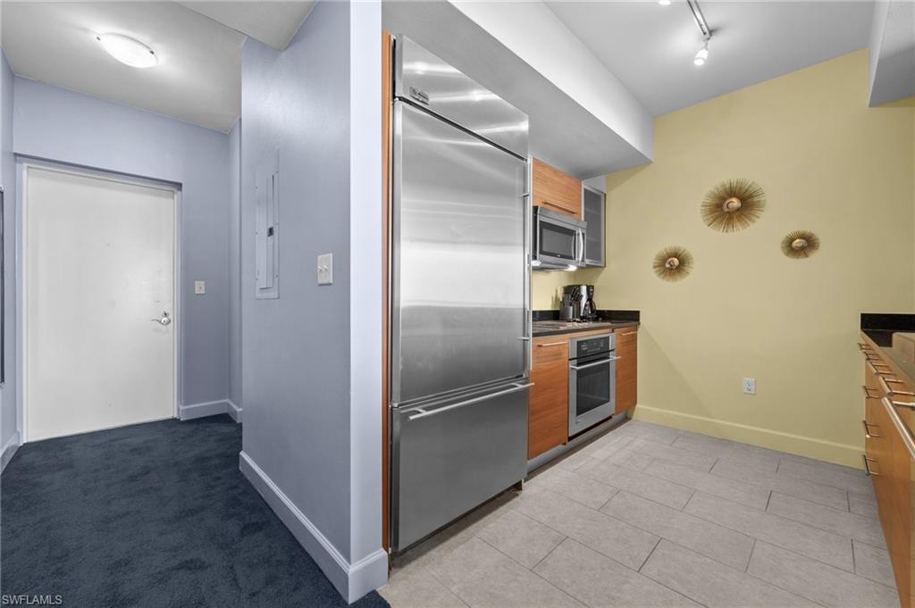 3000 Oasis Grand Boulevard, Unit 906 Fort Myers, FL 33916 - Photo 6 of 21 a kitchen with stainless steel appliances granite countertop a refrigerator and a sink