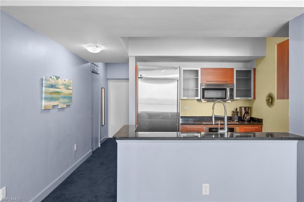 3000 Oasis Grand Boulevard, Unit 906 Fort Myers, FL 33916 - Photo 7 of 21 a living room with stainless steel appliances kitchen island granite countertop a refrigerator and a sink