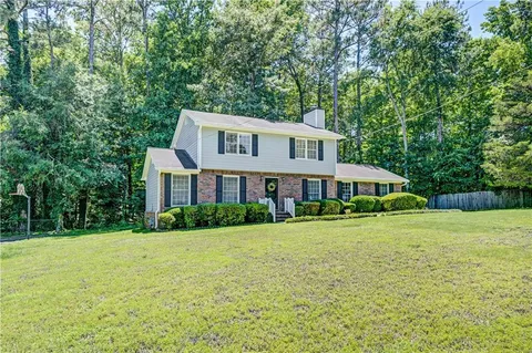 a front view of a house with yard and green space