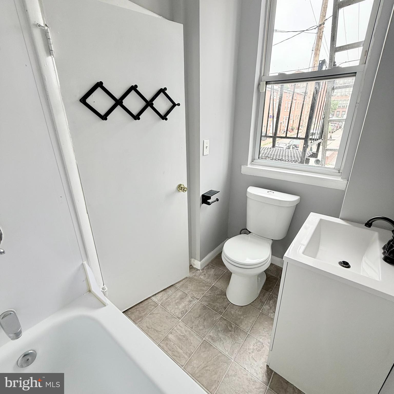 1001 Light Street, Unit 2 Baltimore, MD 21230 - Photo 9 of 11 a white toilet sitting next to a bathroom sink and tub