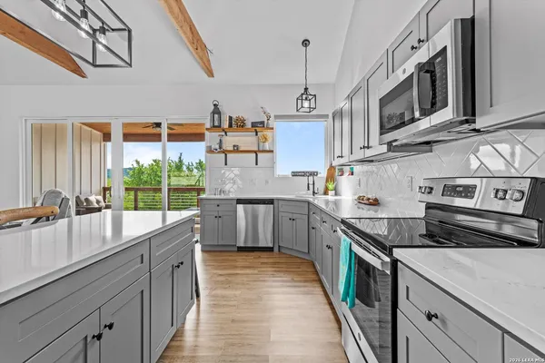 a kitchen with stainless steel appliances granite countertop a sink a stove and a wooden floors