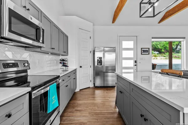 a kitchen with stainless steel appliances granite countertop a stove a sink and a microwave