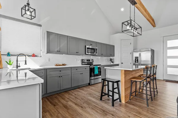 a kitchen with a sink cabinets and wooden floor