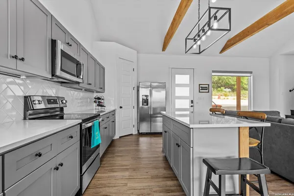 a kitchen with stainless steel appliances granite countertop a sink a stove and cabinets