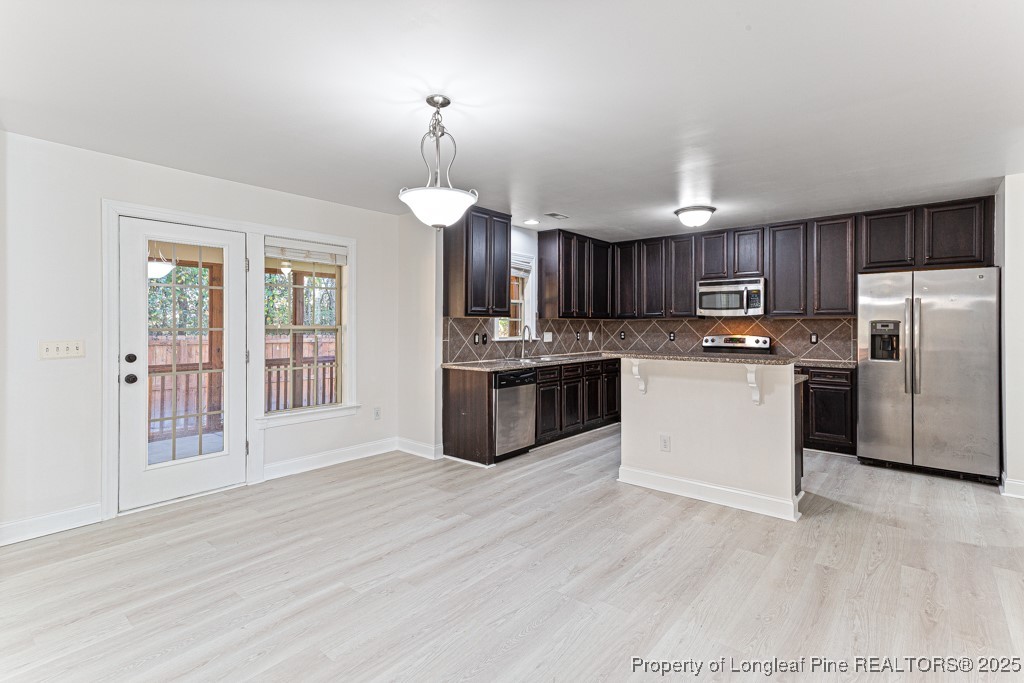 297 Colonist Place Cameron, NC 28326 - Photo 11 of 31 a kitchen with granite countertop wooden floors stainless steel appliances a sink and a window