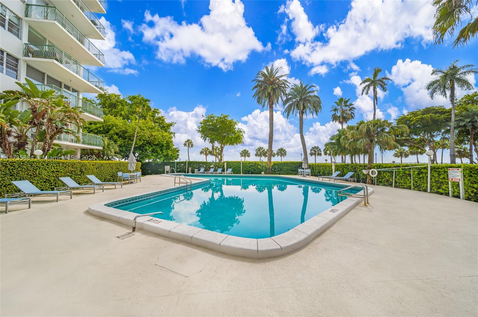 1408 Brickell Bay Drive, Unit 917 Miami, FL 33131 - Photo 16 of 18 a view of a swimming pool with a yard and palm trees