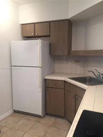 a kitchen with a refrigerator and a sink