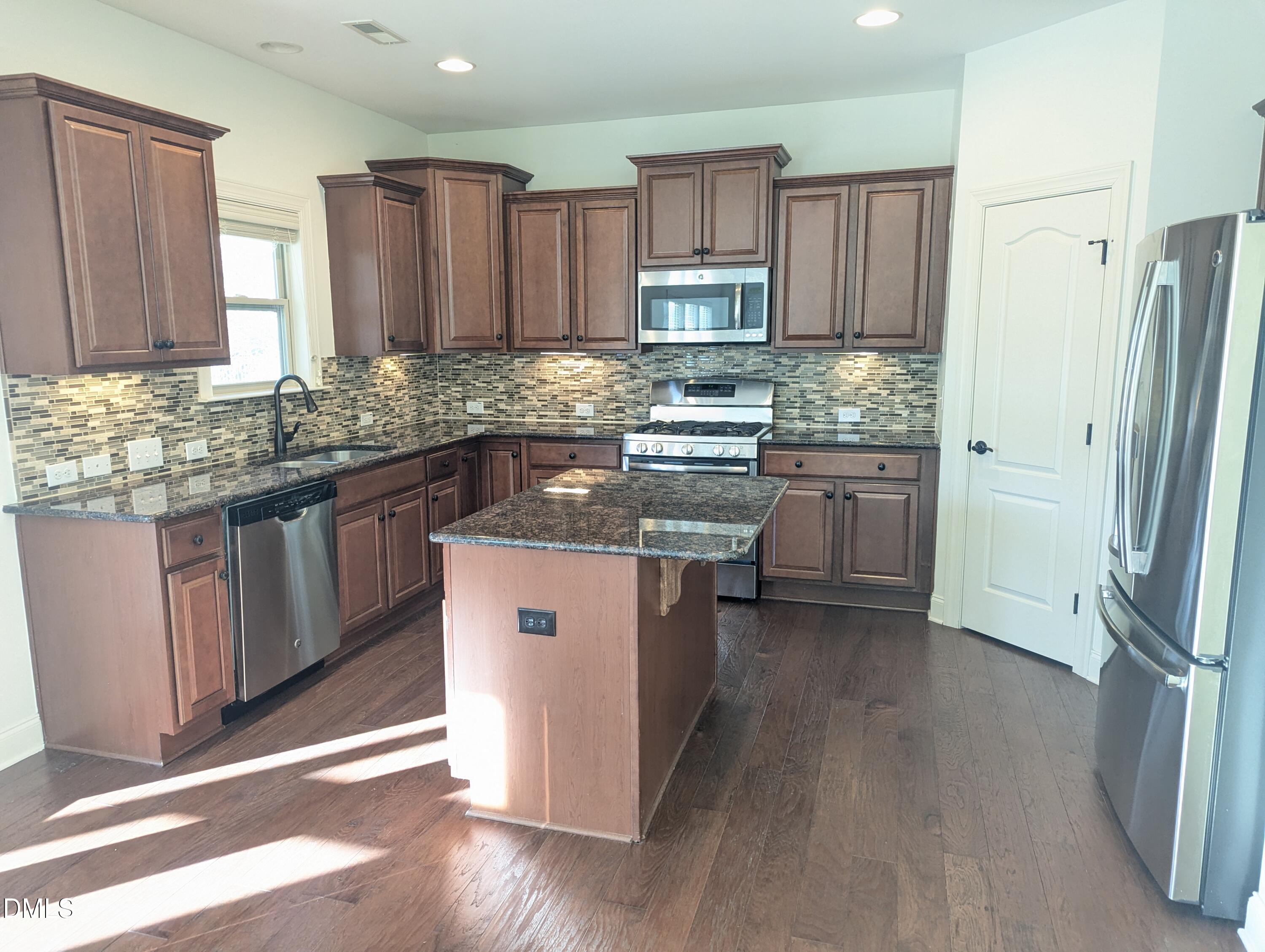 833 Poplar Street Durham, NC 27703 - Photo 4 of 20 a kitchen with stainless steel appliances granite countertop a stove top oven a sink and dishwasher a refrigerator with wooden floor