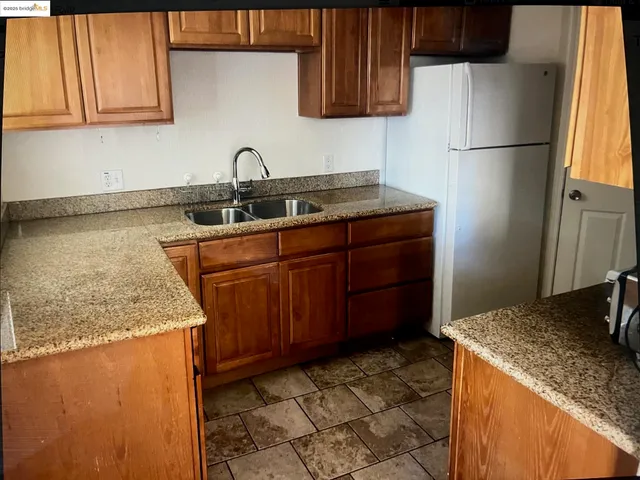 a kitchen with a sink refrigerator and cabinets