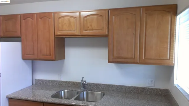 a kitchen with granite countertop a sink and cabinets