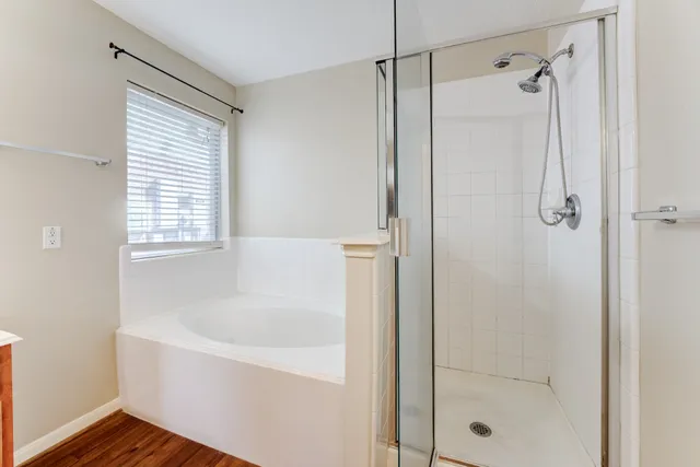a white bath tub sitting next to a shower