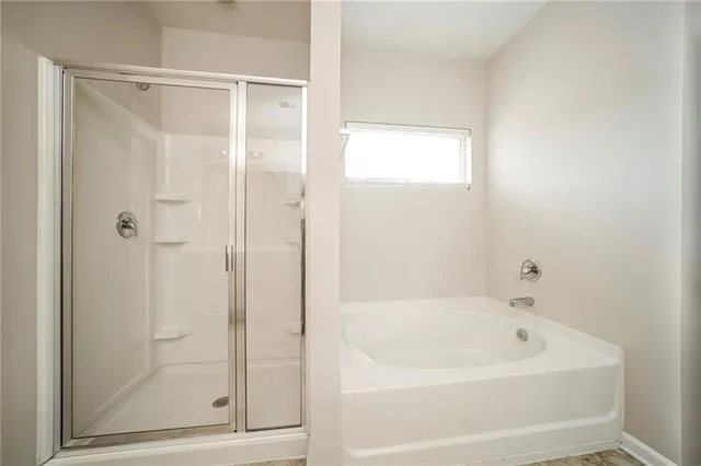 a white bath tub sitting next to a shower