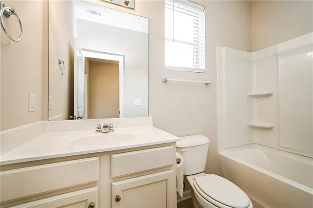 a bathroom with a sink toilet vanity and tub
