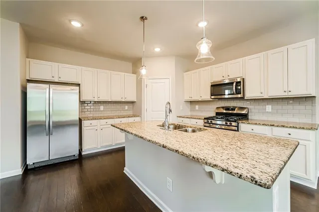 a kitchen with stainless steel appliances granite countertop a sink refrigerator and microwave