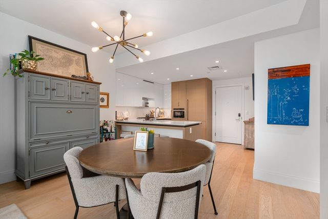 a kitchen with a table chairs refrigerator and cabinets