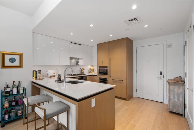 a kitchen that has a lot of cabinets and refrigerator in it