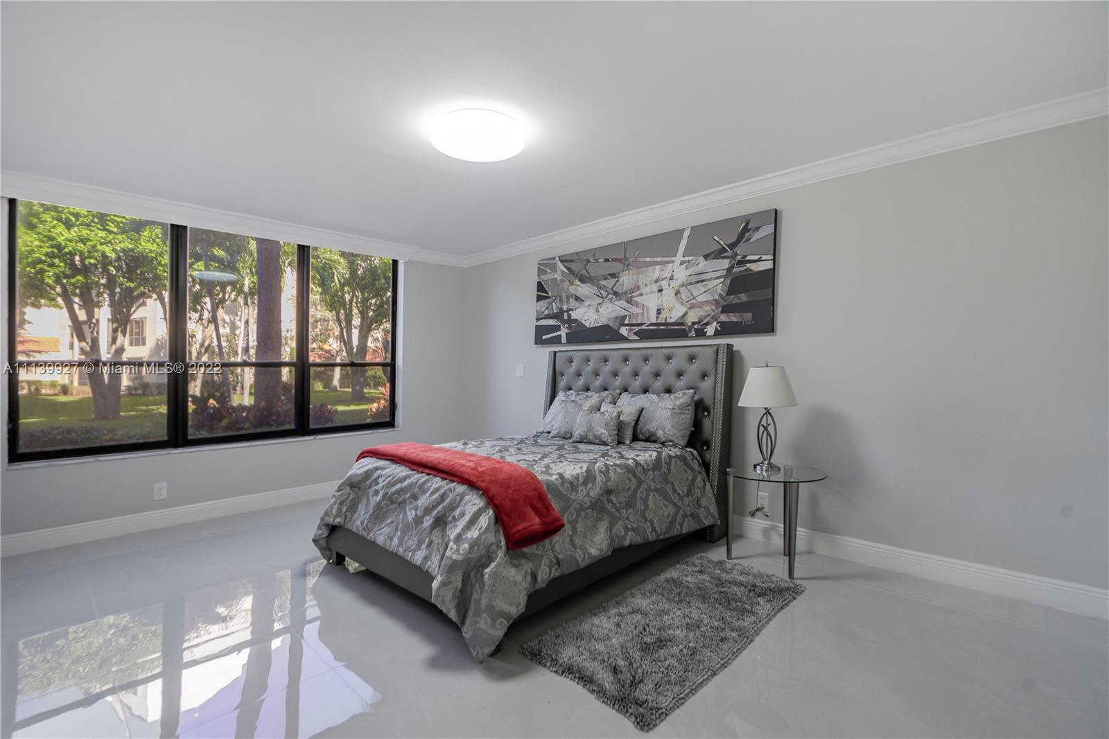 Boca Pointe Boca Raton, FL 33433 - Photo 16 of 41 a bedroom with a bed lamp and a large window