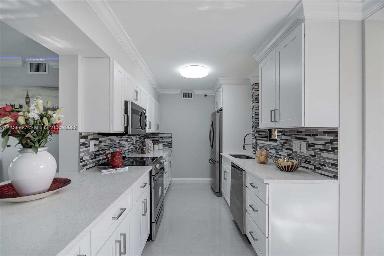 Boca Pointe Boca Raton, FL 33433 - Photo 2 of 41 a kitchen with stainless steel appliances a sink stove and cabinets