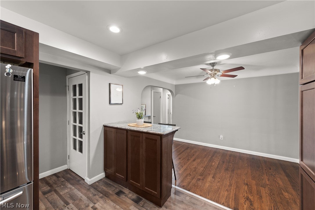 21779 Eaton Road Cleveland, OH 44126 - Photo 12 of 46 Kitchen featuring stainless steel refrigerator, dark hardwood / wood-style flooring, ceiling fan, and light stone countertops
