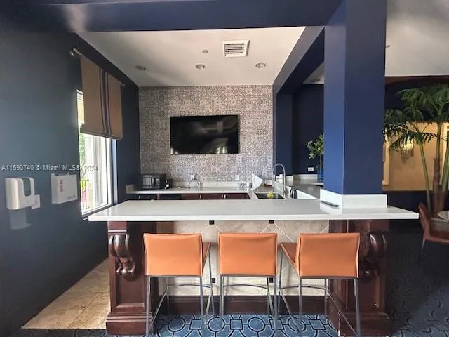 a kitchen with a table chairs refrigerator and microwave