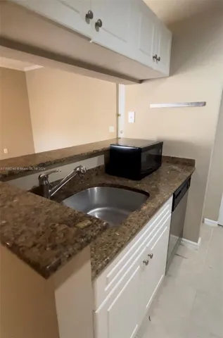 a kitchen with granite countertop a sink and a stove