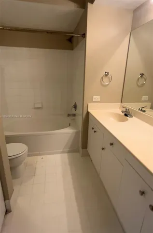 a bathroom with a granite countertop sink a toilet and a bathtub