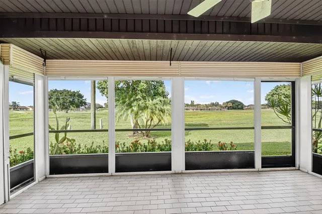 a room with lots of tables a large window and chairs