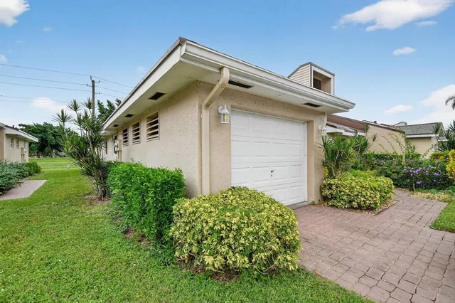 a car parked in front of a house with a yard