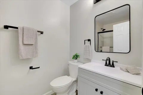 a bathroom with a sink vanity mirror and toilet