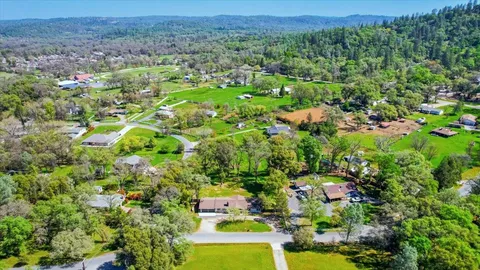 a front view of a house with a yard and trees