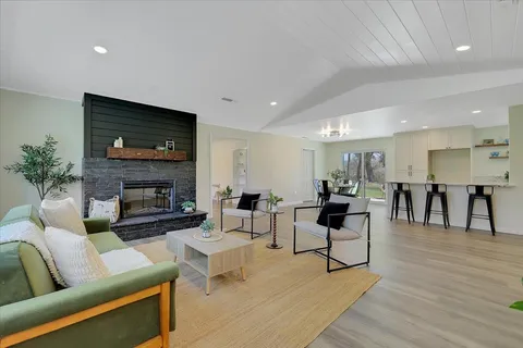 a living room with furniture a flat screen tv and a fireplace