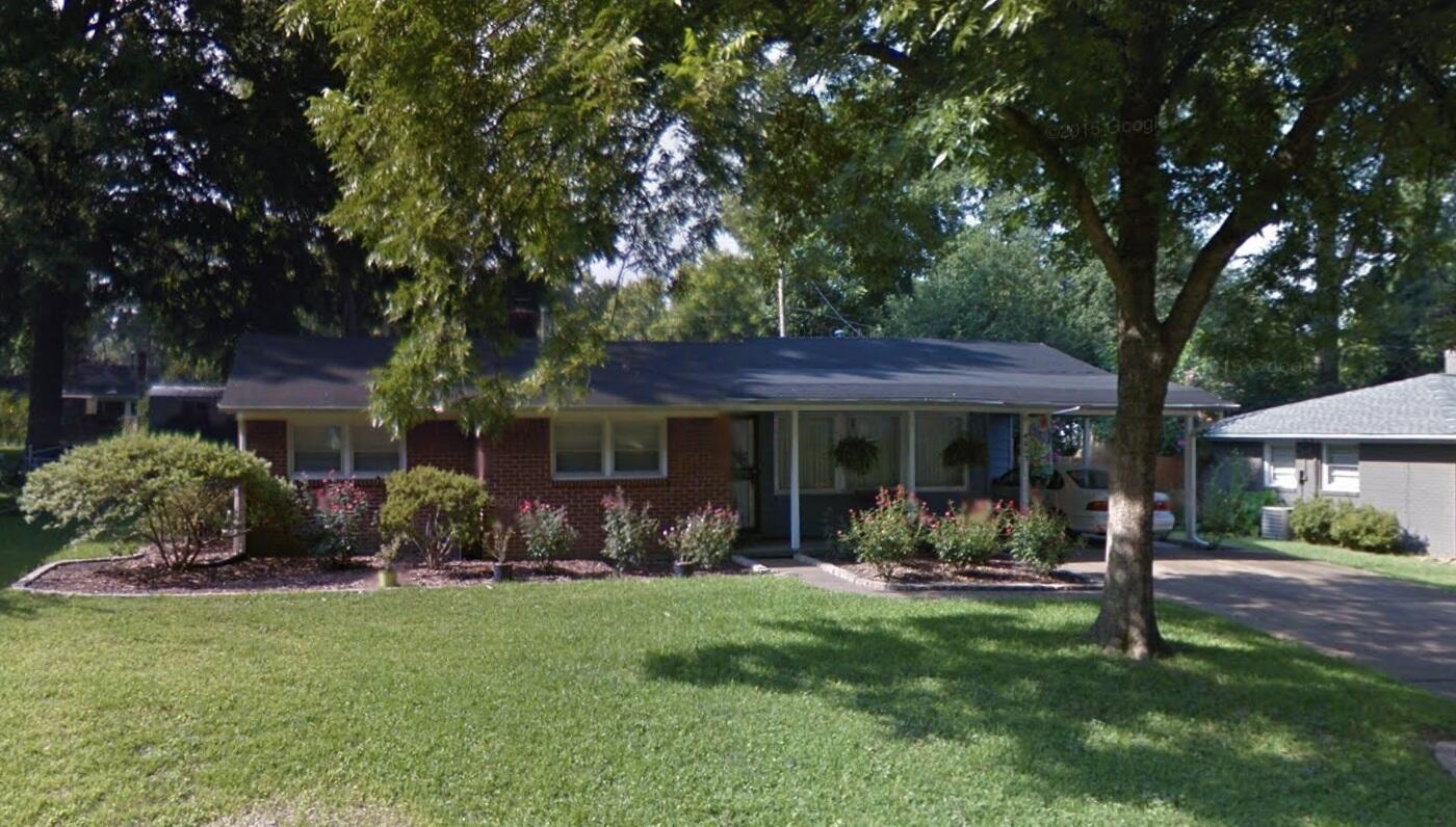 a backyard of a house with table and chairs
