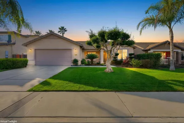 front view of house with a yard and palm trees