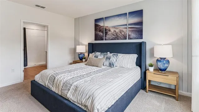 a bedroom with bed and paintings on the wall