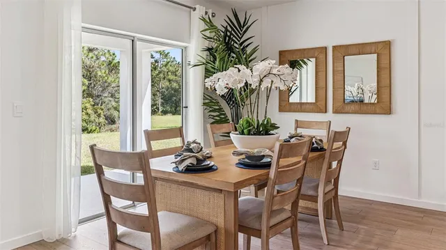 a dining room with furniture potted plants and wooden floor