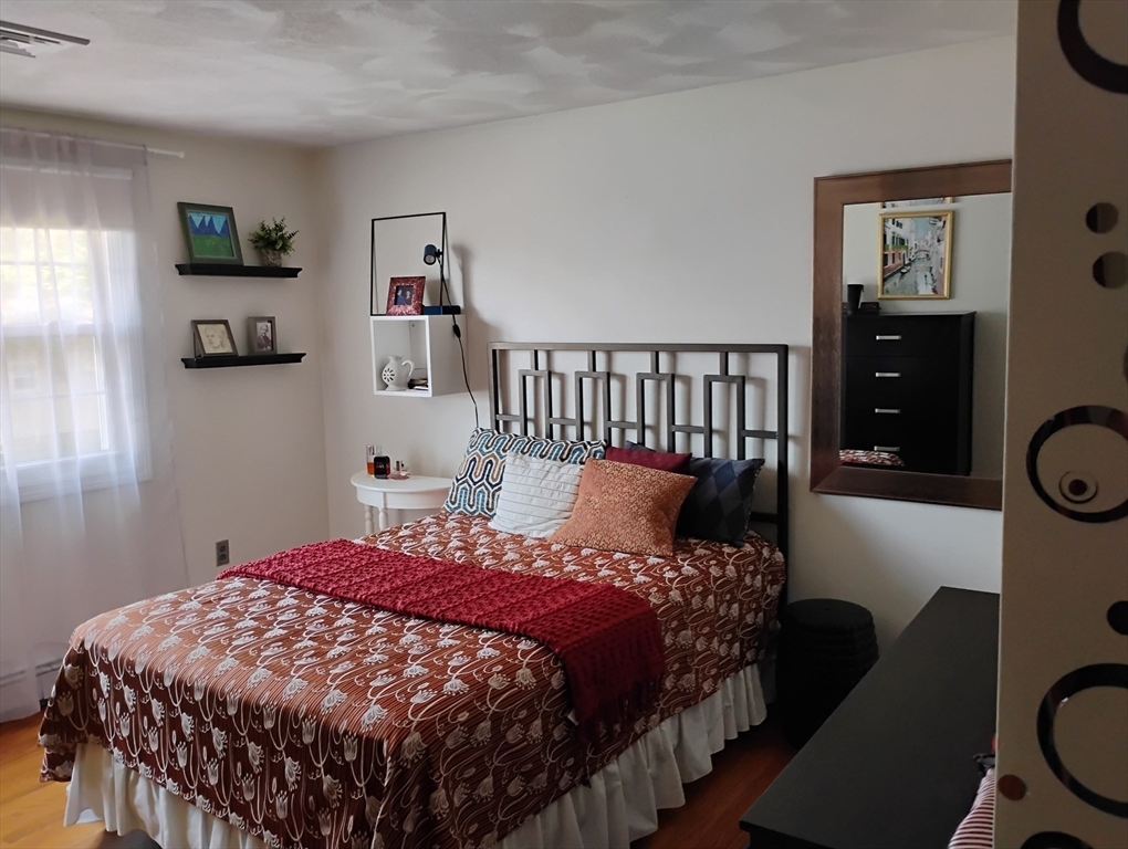 9 Packard Road Milford, MA 01757 - Photo 18 of 29 a bedroom with a bed a painting on the wall and a window